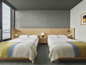 Two queen beds next to a floor-to-ceiling window