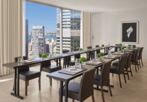 Sala de reuniones con mesa en forma de U y vista a la ciudad