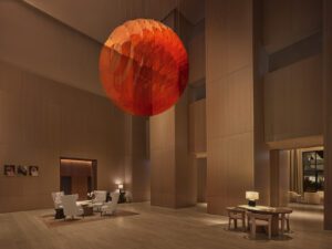 Image of hotel lobby with large orange statement light fixture